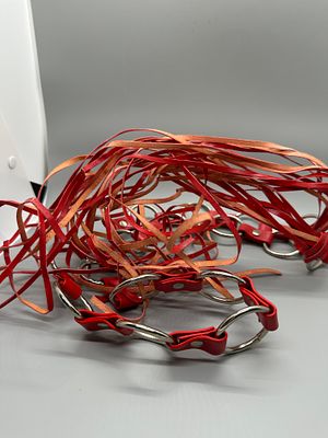 Red and Silver Toned Strapped Fashion Accessory. A red fashion accessory featuring multiple 