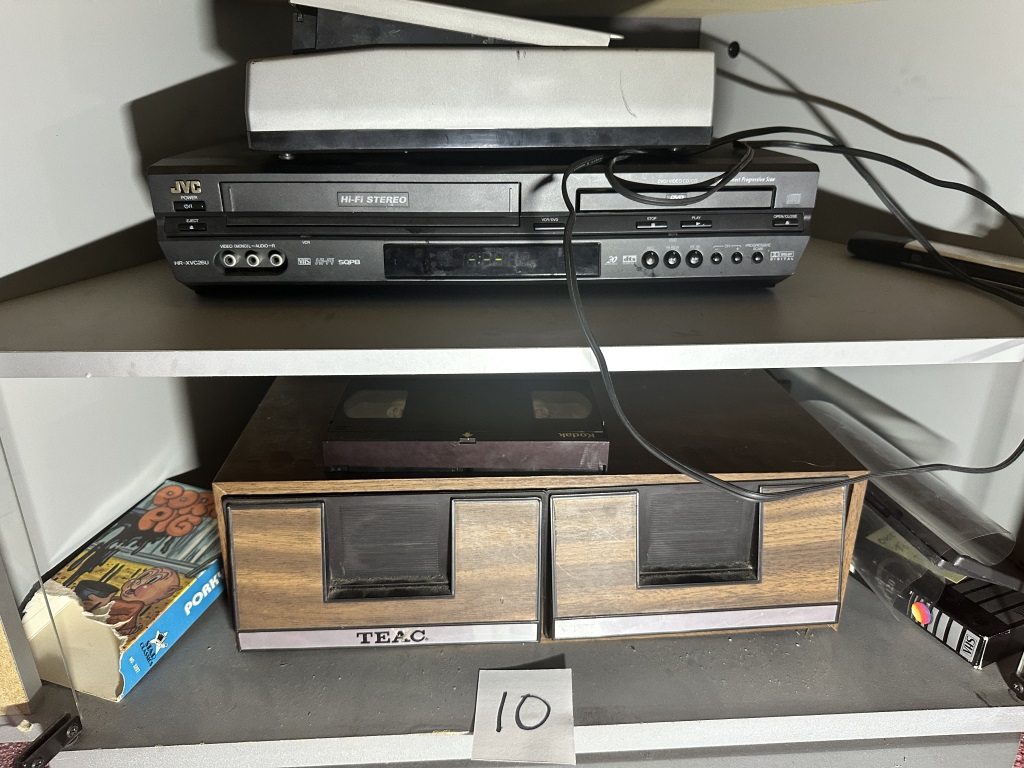 JVC VCR/DVD combo with Tape rewinder and assorted media on sheves
