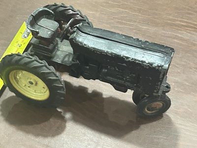 Vintage Metal Toy Farm Tractor. Black painted metal tractor with yellow rear wheels and molded 