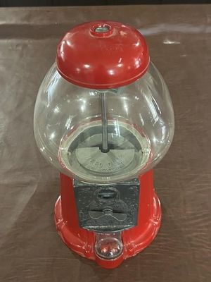 Vintage Carousel Industries Gumball Machine. Red metal coin-operated gumball machine with clear 