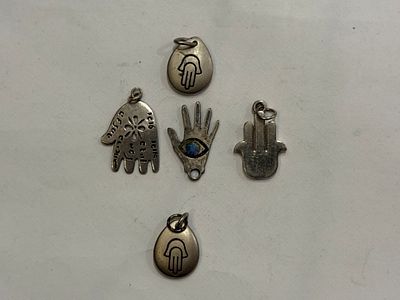 A collection of hand-shaped (Hamsa) pendants. 
Materials not tested.