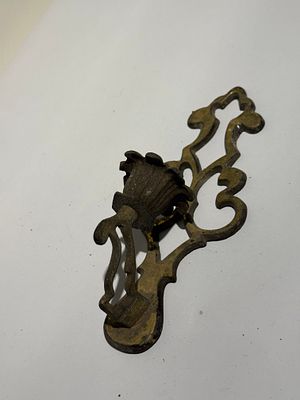 פריט 136. פמוט קיר עשוי פליז/נחושת, בעיצוב פתוח ומעוטר. עם זרוע מתעקלתומחזיק נר מרכזי.