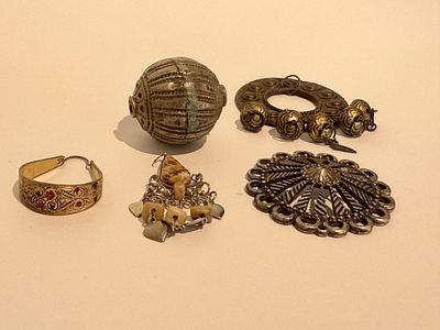 לוט תכשיטים ותליונים, הכולל מספר פריטי מתכת מעוטרים בעבודת יד ובגימור ישן.