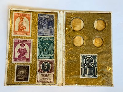 חוברת מקורית מהוותיקן הכוללת סדרת בולים מוקדמת של Poste Vaticane, מוצגת במסגרת דקורטיבית מוזהבת 