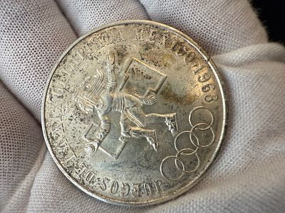 מטבע 25 פסו, שנת 1968, כסף בטוהר 0.720, משקל 22.7 גרם, שהוטבע לכבוד המשחקים האולימפיים מקסיקו 