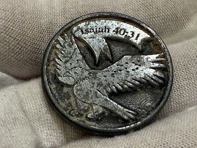 מדליית השראה דתית עשויה מתכת בגוון כהה. 
בצדה האחד מופיעה דמות נשר בפריסה, ולמעלה הכיתוב: 
