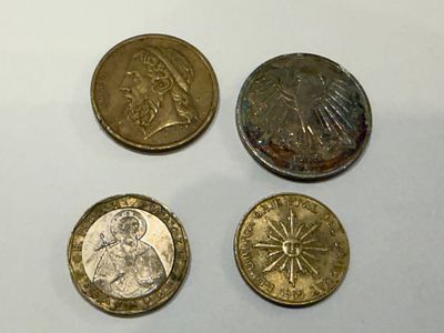 לוט מטבעות מגוון מהעולם, הכולל מטבעות מתקופות שונות עם עיצובים היסטוריים ודמויות.