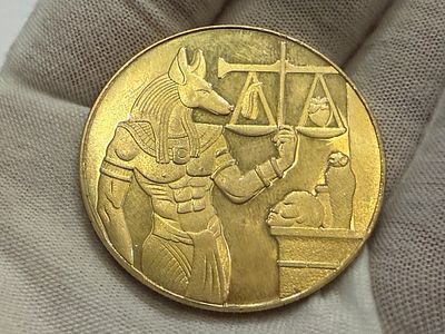 אסימון/מטבע פנטזיה בעיצוב מצרי עתיק, המציג דמות האל אנוביס לצד מאזניים וסצנות מהמיתולוגיה 
