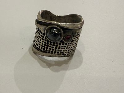 Silver ring featuring unique handcrafted design, with a wide top structure. The front is set 