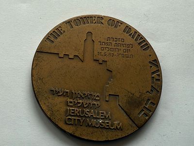 מדליה ישראלית גדולה בנושא “מגדל דוד” – מוזיאון העיר ירושלים. בצד אחד מופיע עיצוב טיפוגרפי של שם 