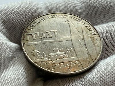 מטבע הזיכרון השני של חנוכה מוקדש לציון 50 שנה ליישוב הקיבוצי דגניה: "אם הכפרים השיתופיים". 