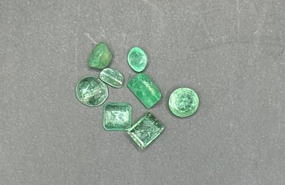 Parcel of eight loose natural emeralds in mixed cuts — emerald-cut, oval, round, pear and 