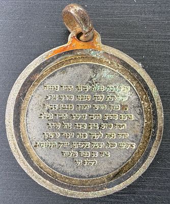 A Jewish amulet pendant (kamea) of metal. One side bears the verse “Shema Yisrael Hashem 