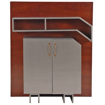 AN ART DECO PAINTED TWO DOOR CABINET WITH ANGULAR BOOKSHELF MOUNTED ON A MAHOGANY WALL PANEL. An 