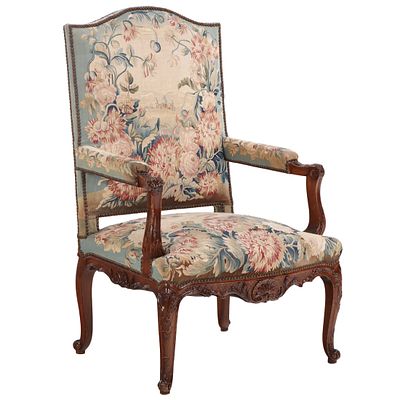 A FRENCH LOUIS XV STYLE CARVED WALNUT OPEN ARMCHAIR HAVING FLORAL NEEDLEPOINT UPHOLSTERY. A 