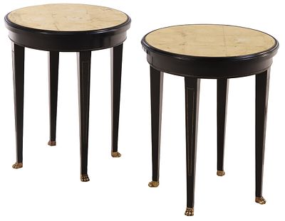 A PAIR OF ROUND EBONIZED END TABLES HAVING GOLD GILT GLASS TOPS, INSET BRASS BEADING AND BRASS. 