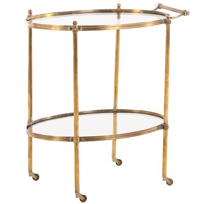 AN OVAL BRASS AND GLASS BAR CART HAVING BALL FORM FINIALS AND RESTING ON WHEELS CIRCA 1970. An 