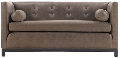 A TAILORED EVEN ARM LEATHER SOFA HAVING BUTTON BACK UPHOLSTERY AND TWO BOLSTER CUSHIONS. A 