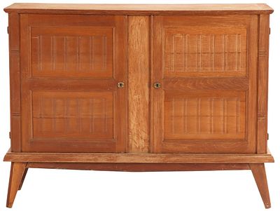 A FRENCH OAK SERVER HAVING TWO DOORS IN THE MANNER OF RENE GABRIEL C 1940. A french oak server 