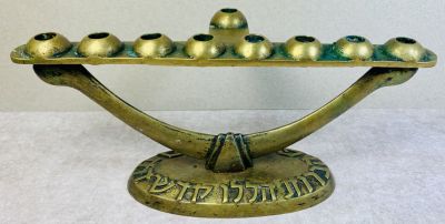 פל-בל - חנוכיה שנות ה50-60 
עשויה פליז . כיתוב : ״ הנרות הללו קדש הם ״ . עבודה לא שכיחה . 