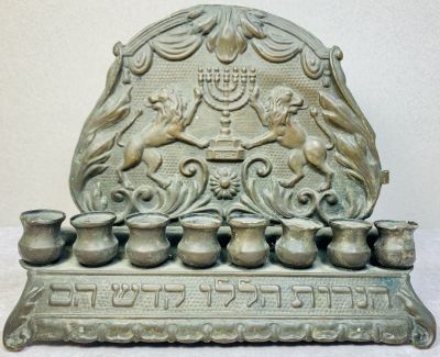 חנוכיית נחושת עתיקה 
המאה ה19 . פולין . עיטורי אריות ומנורה . כיתוב - ״ הנרות הללו קדש הם ״ . 