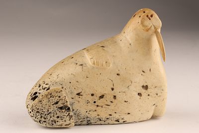 Inuit Whale Bone Sculpture of a Walrus. A compact Inuit carving of a walrus in fossilized bone 