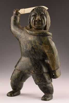 Large Inuit Soapstone Hunter with Raised Knife, 8.75 Inches. Inuit soapstone sculpture depicting 