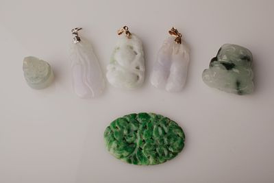 Chinese Carved Jadeite Pendant Group With Gold Bails. A Group of Chinese carved jadeite 