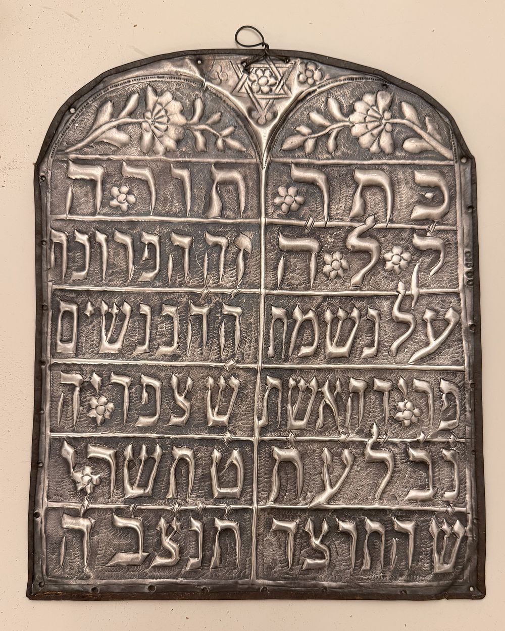 טס כסף לספר תורה - לאחר תרצ"ד. 
טס כסף לספר תורה עם הנצחה. 
מחובר לפלטת מתכת. 
26*21 ס"מ. 