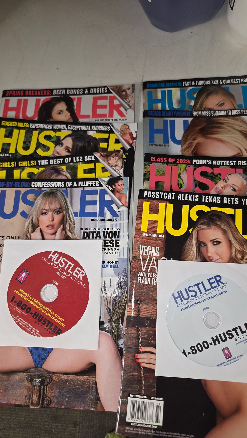 Lot 173 – A Collection of Adult Hustler Magazines and Two Bonus DVDs