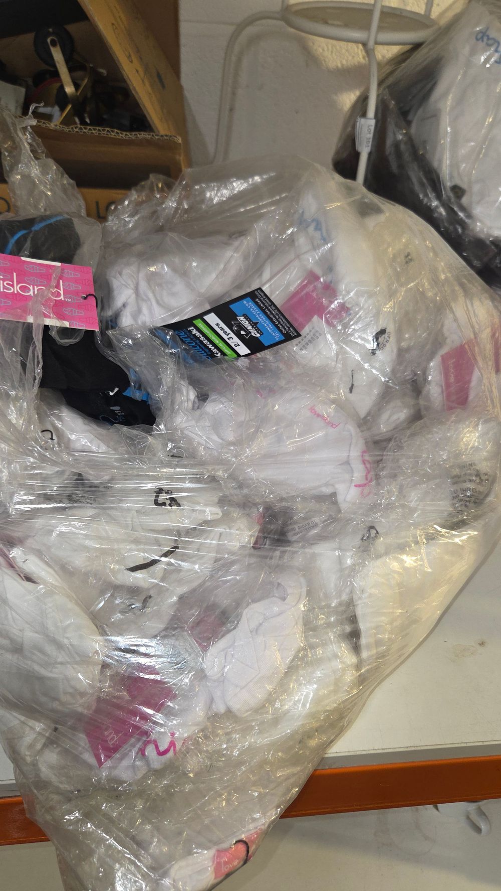 Lot 159 – A Collection of New Clothing Including Kawasaki and Love Island Branded Textiles