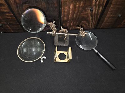 A Collection of Magnifying Tools and Helping Hand Stand. A collection of silver and gold-tone 