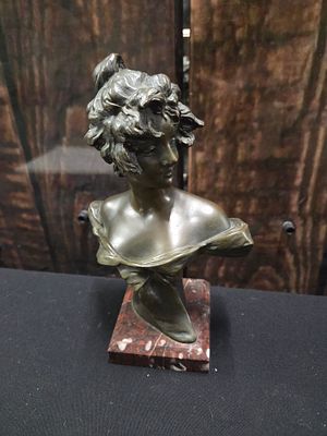 Bronze Sculptural Bust on Marbled Stone Base. A dark bronze-toned sculptural bust of a figure 