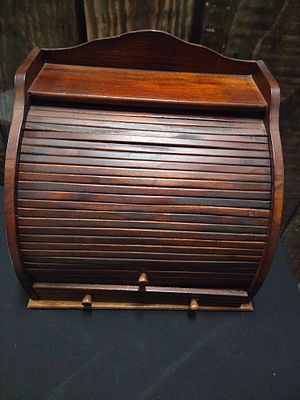 Wooden Roll Top Desk Organiser with Tambour Front. A dark brown wooden roll-top desk organiser 