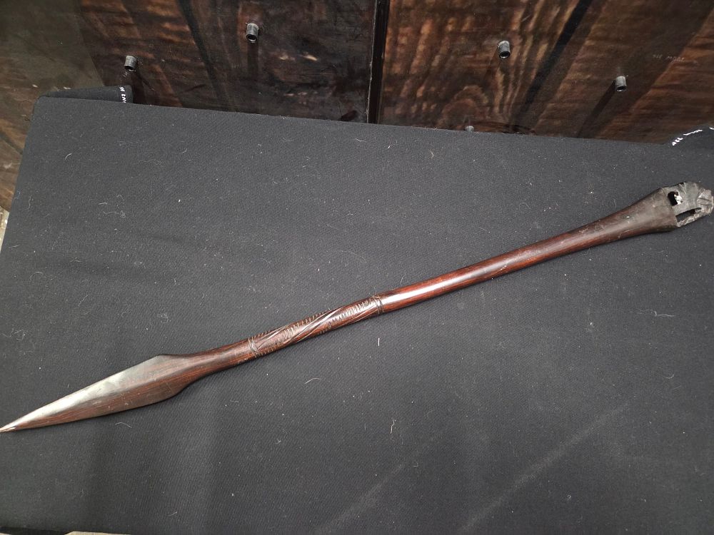 Carved Wooden Zulu Style Stabbing Spear. A dark brown carved wooden spear featuring a pointed 