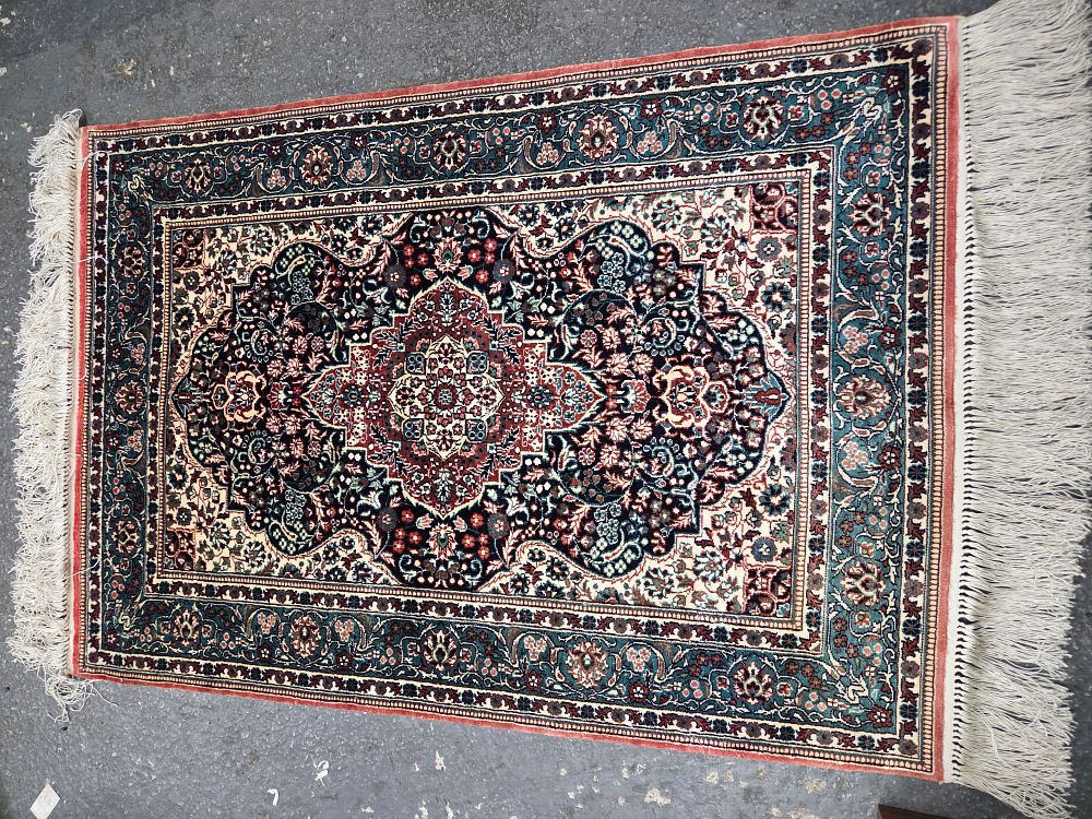 Multi-coloured silk carpet with intricate floral patterns. A multi-coloured silk carpet 