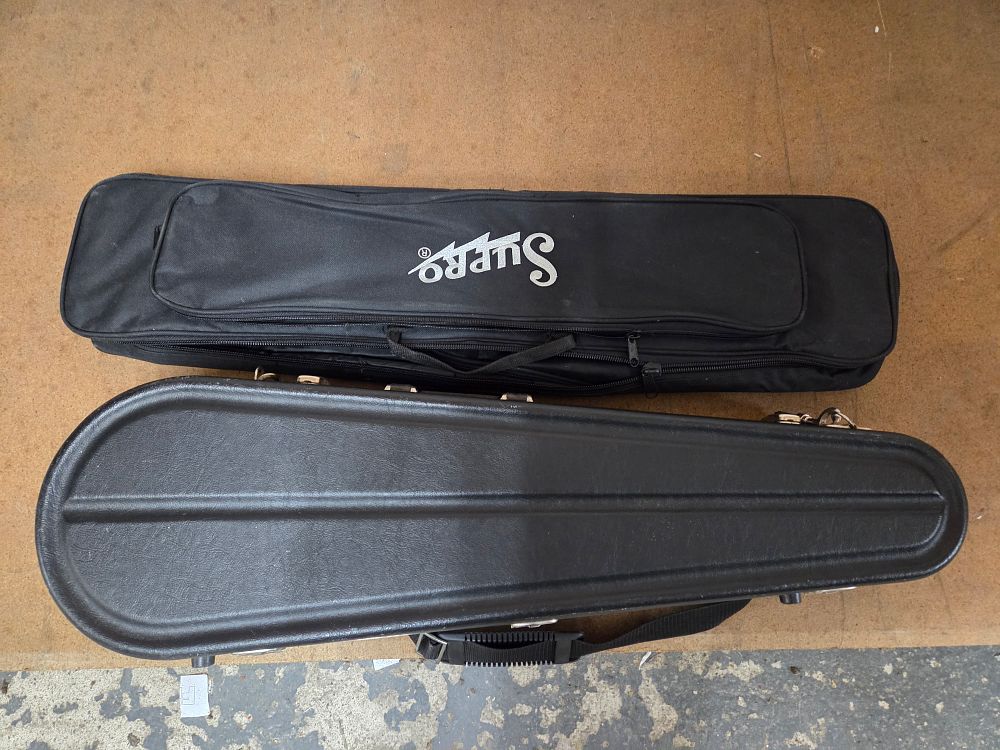 Lot 505 – Two black instrument cases including a Supro gig bag