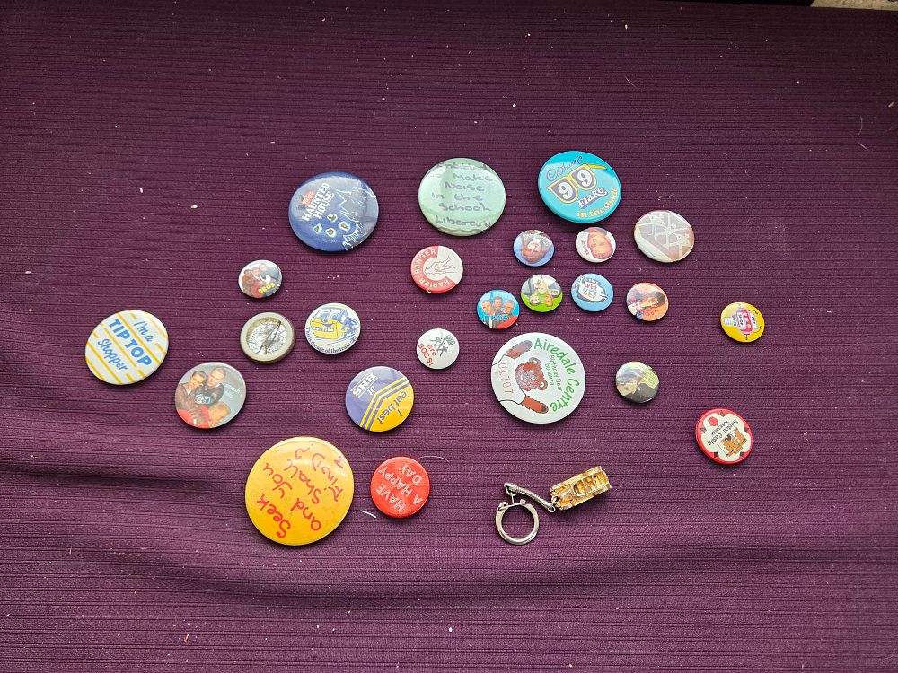 Lot 644 – An Assortment of Vintage UK Promotional and Pop Culture Pinback Badges and a Double-Decker Bus Keychain