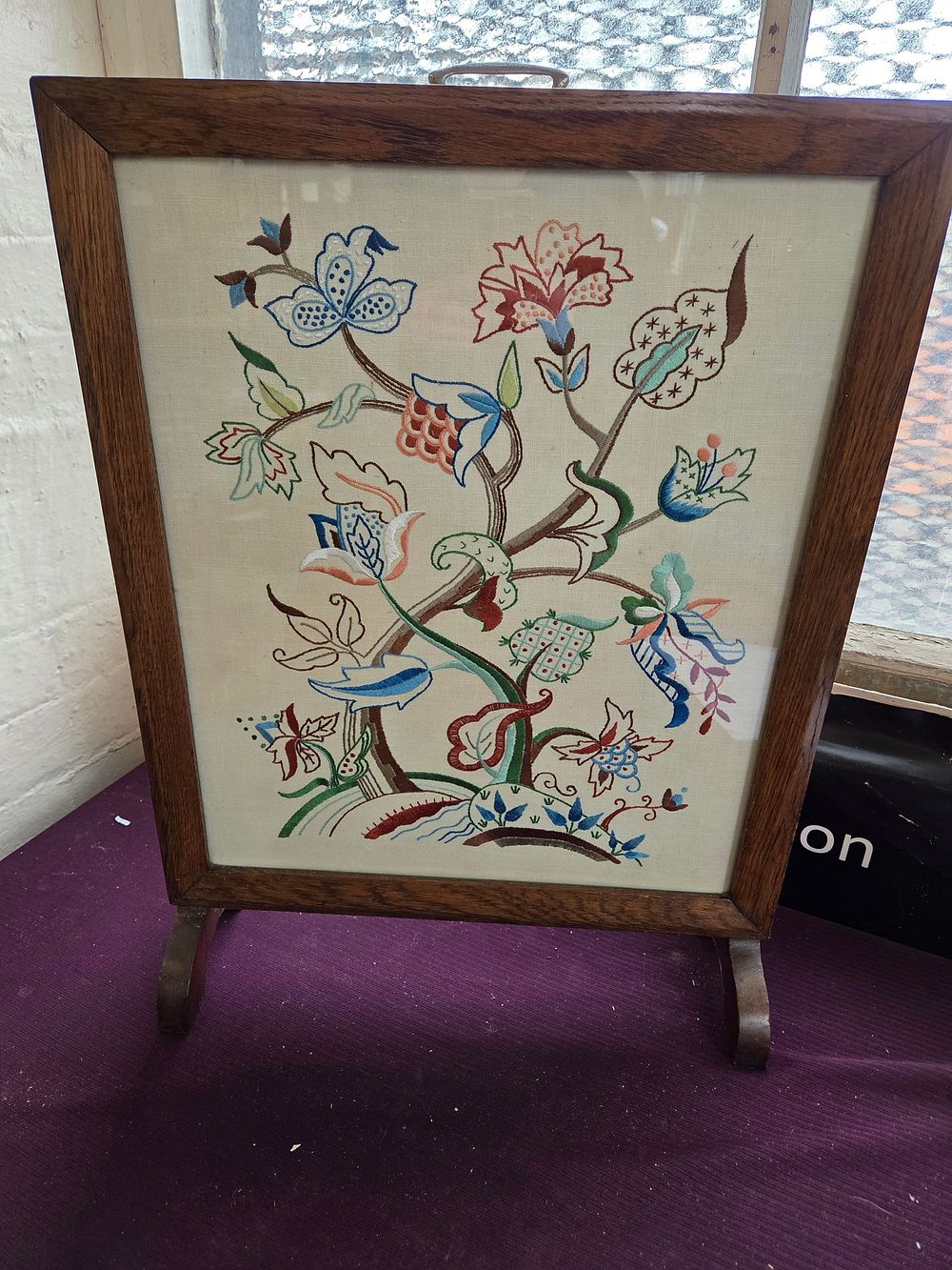 Lot 376 – An early 20th-century oak framed crewel work fire screen