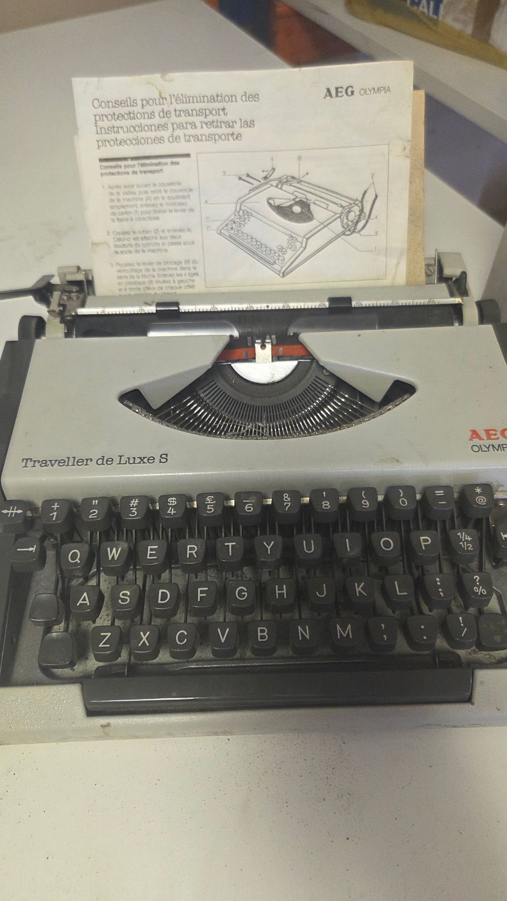 Lot 259 – An AEG Olympia Traveller de Luxe S Portable Typewriter and Instruction Sheet
