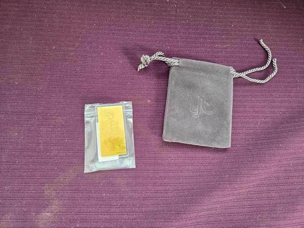 Lot 613 – A 24k Gold Bullion Bar with Dragon Motif and TJC Pouch