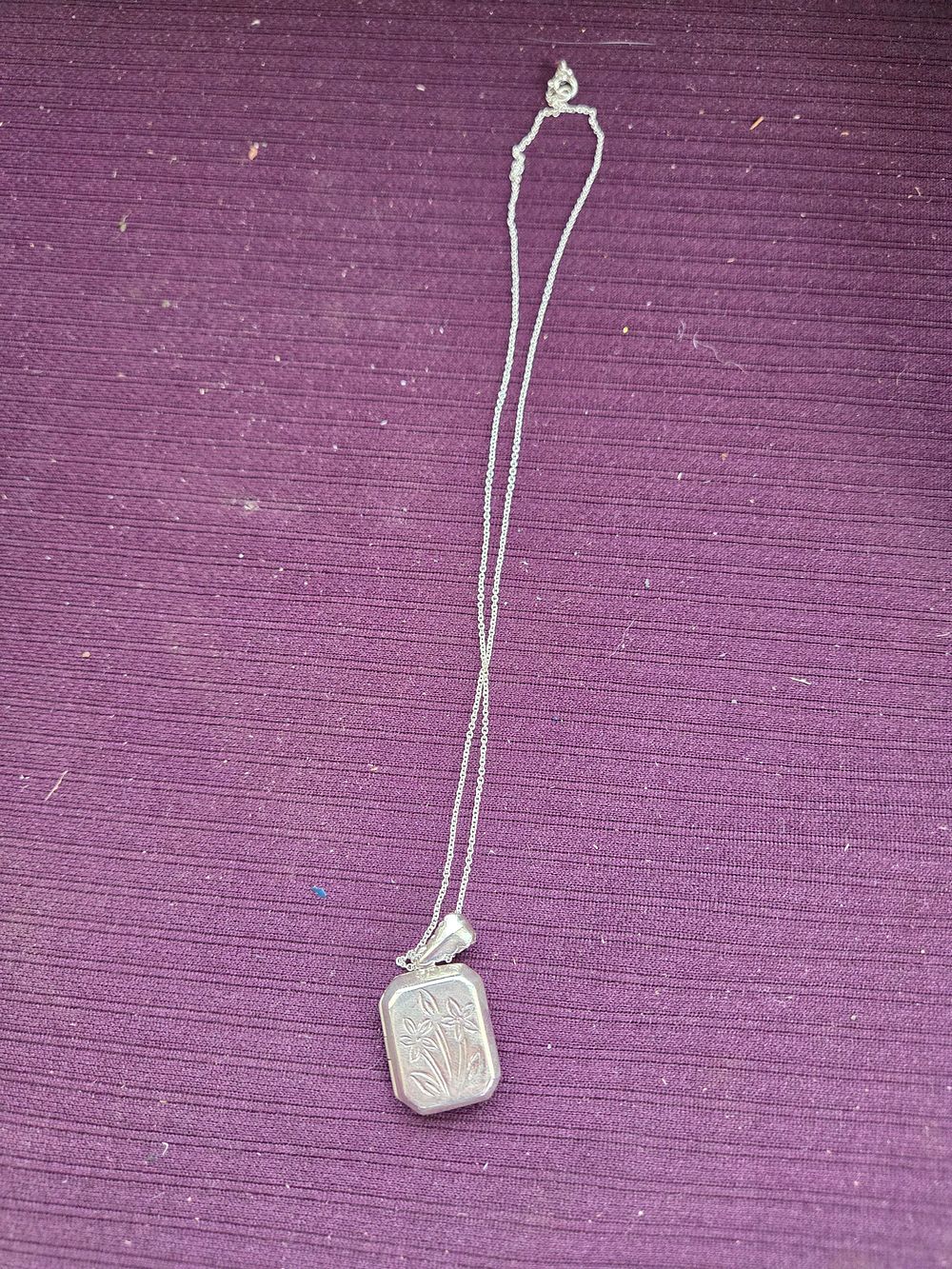 Lot 634 – A sterling silver rectangular floral engraved locket on a fine rope chain 6.33g
