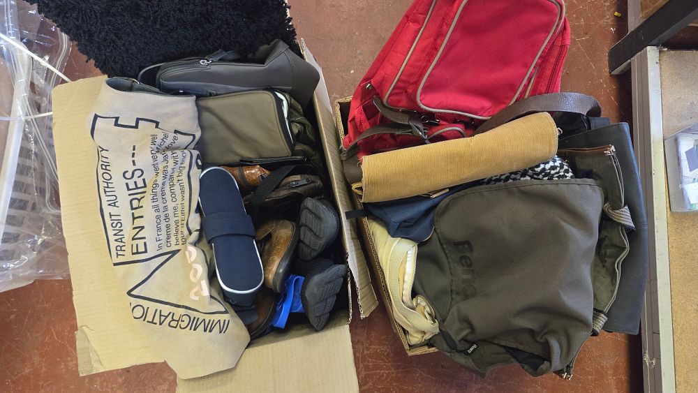 Lot 174 – Two Boxes of Assorted Travel Bags, Backpacks, and Footwear including Bench