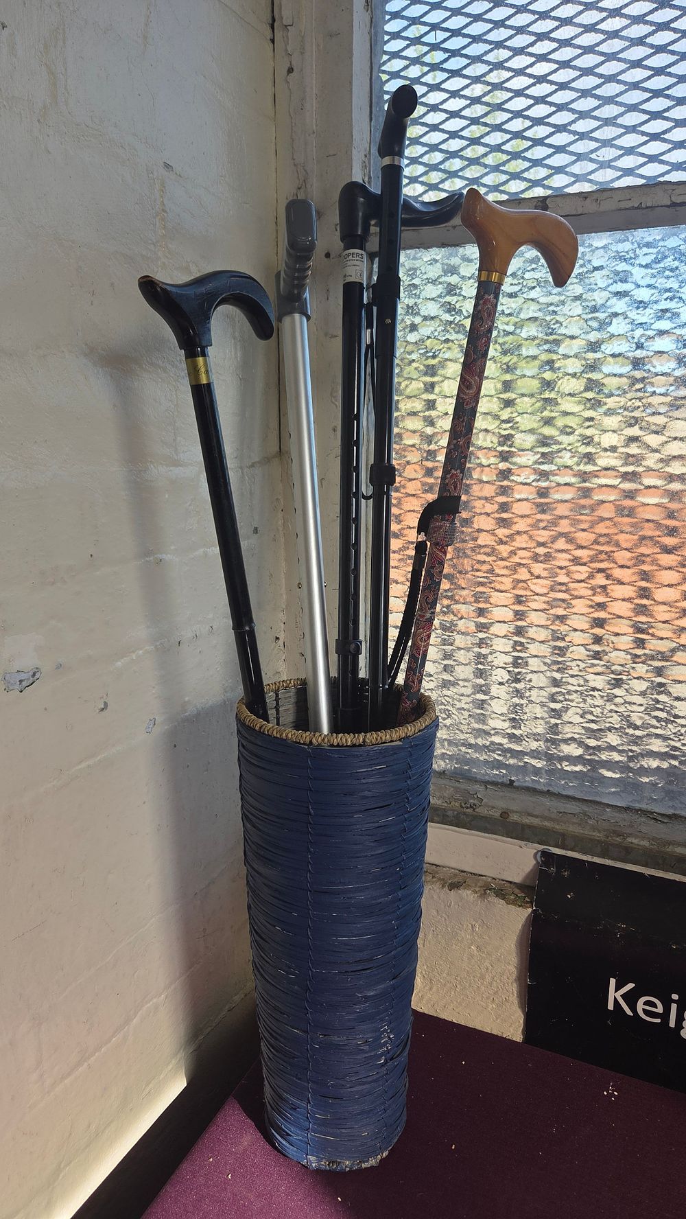 Lot 363 – A Group of Five Walking Canes and a Forearm Crutch in a Woven Stand