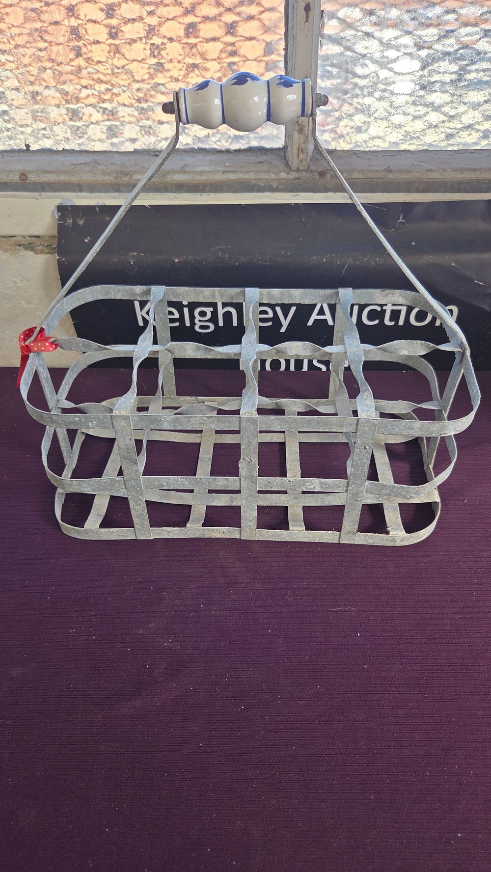Lot 257 – A vintage galvanised metal six-compartment bottle carrier with ceramic handle
