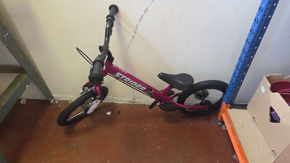 Lot 215 – A New Strider 14x Sport convertible balance bike in fuchsia