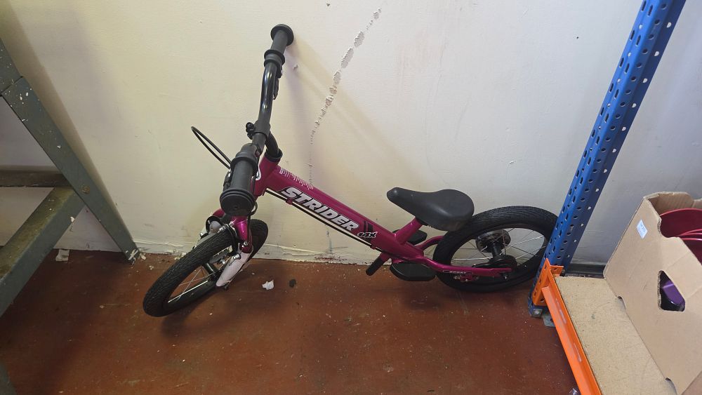 Lot 216 – A New Strider 14x Sport convertible balance bike in fuchsia