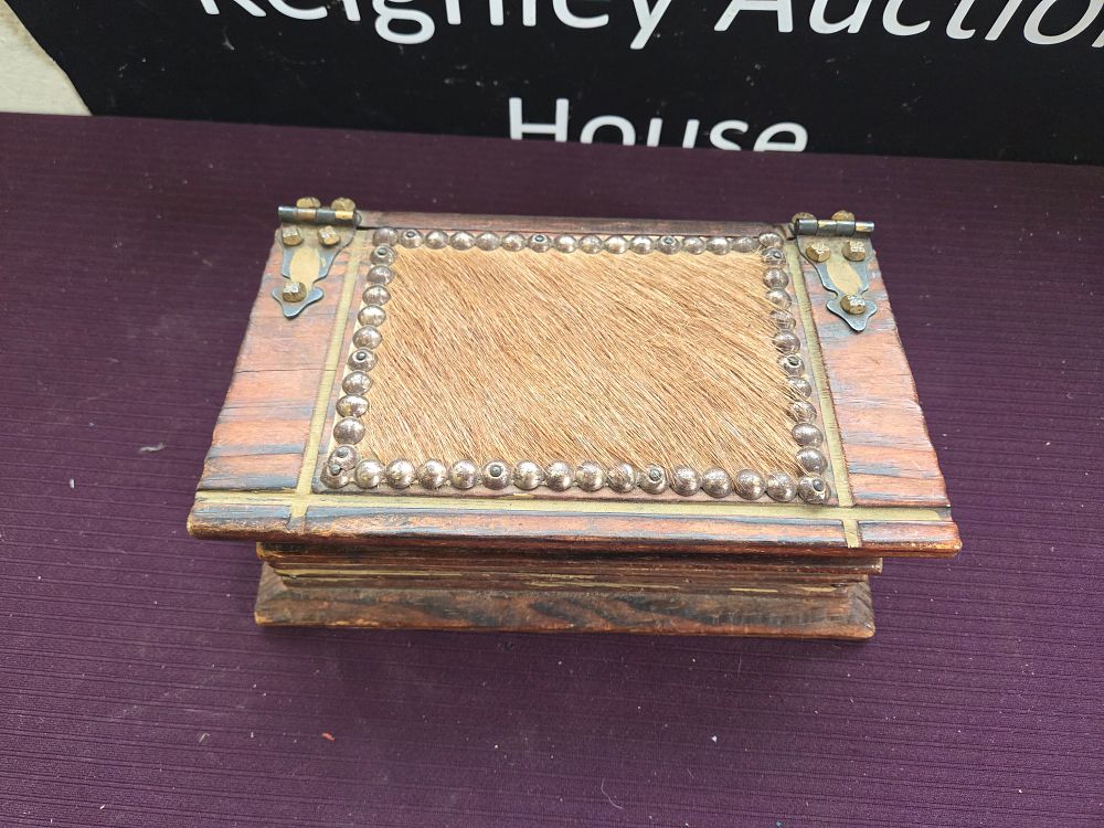 Lot 618 – A Rustic Wooden Trinket Box with Hair-on Hide Inlay and Studded Decoration