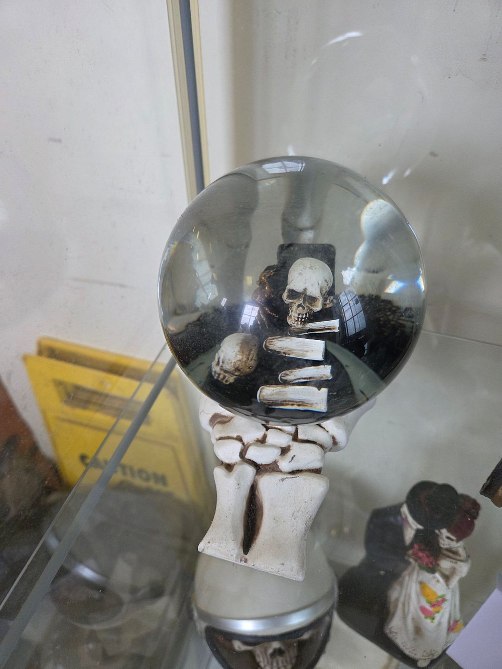 Lot 602 – A Gothic-style skeletal hand water globe containing miniature skulls