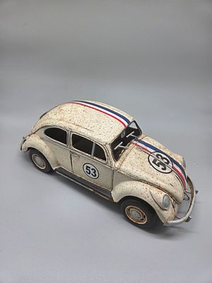 A decorative metal model of a Volkswagen Beetle in the style of Herbie the Love Bug